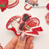 Kırmızı temalı, yıldız desenli hologram sticker paketinin farklı açılardan çekilmiş fotoğrafı