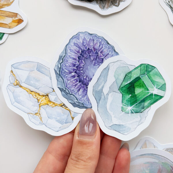 Mineral ve kristal temalı 34 adet suya dayanıklı vinil sticker setinin pürüzsüz bir yüzeydeki görünümü.