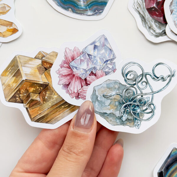 Mineral ve kristal temalı 34 adet suya dayanıklı vinil sticker setinin pürüzsüz bir yüzeydeki görünümü.