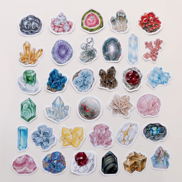 Mineral ve kristal temalı 34 adet suya dayanıklı vinil sticker setinin pürüzsüz bir yüzeydeki görünümü.