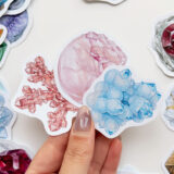 Mineral ve kristal temalı 34 adet suya dayanıklı vinil sticker setinin pürüzsüz bir yüzeydeki görünümü.